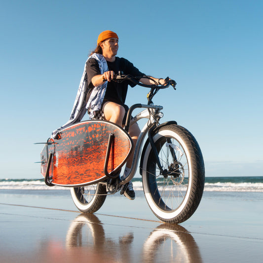 Longboard carried on an Ampd Bros bike surf rack