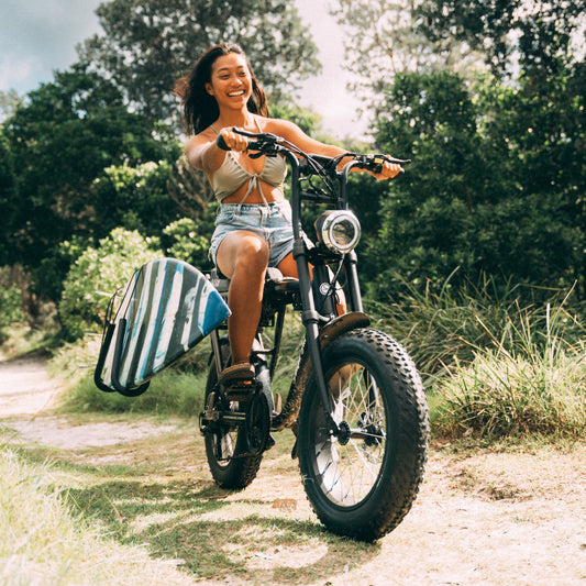 Surfboard carried on an Ampd Bros ACE e-bike with the Moped Surf Rack